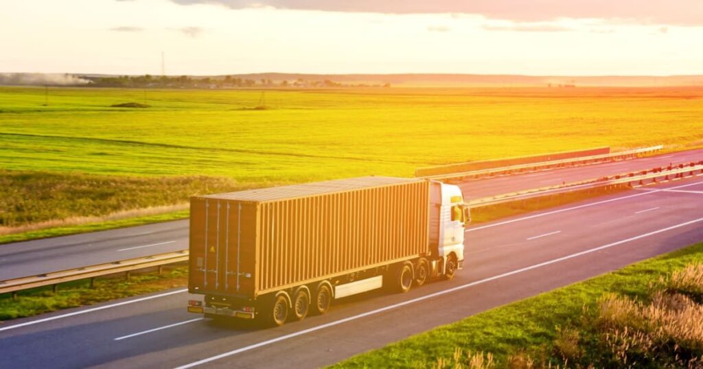 camion qui roule sur l'autoroute avec un coucher de soleil 