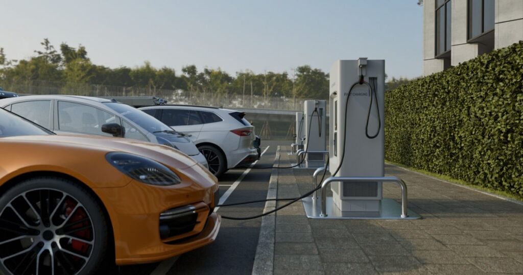 Des voitures électriques sont garées sur un parking de bornes de recharge. 